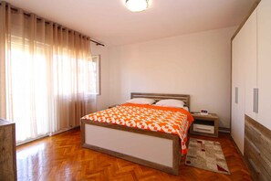 Un dormitorio con una cama de madera, una mesita de noche y un suelo de madera.