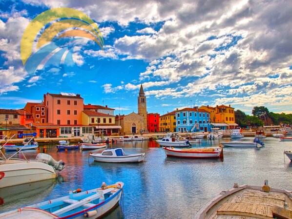 Waterfront views of boats docked along the water's edge, with a historic church and colorful buildings in the background.