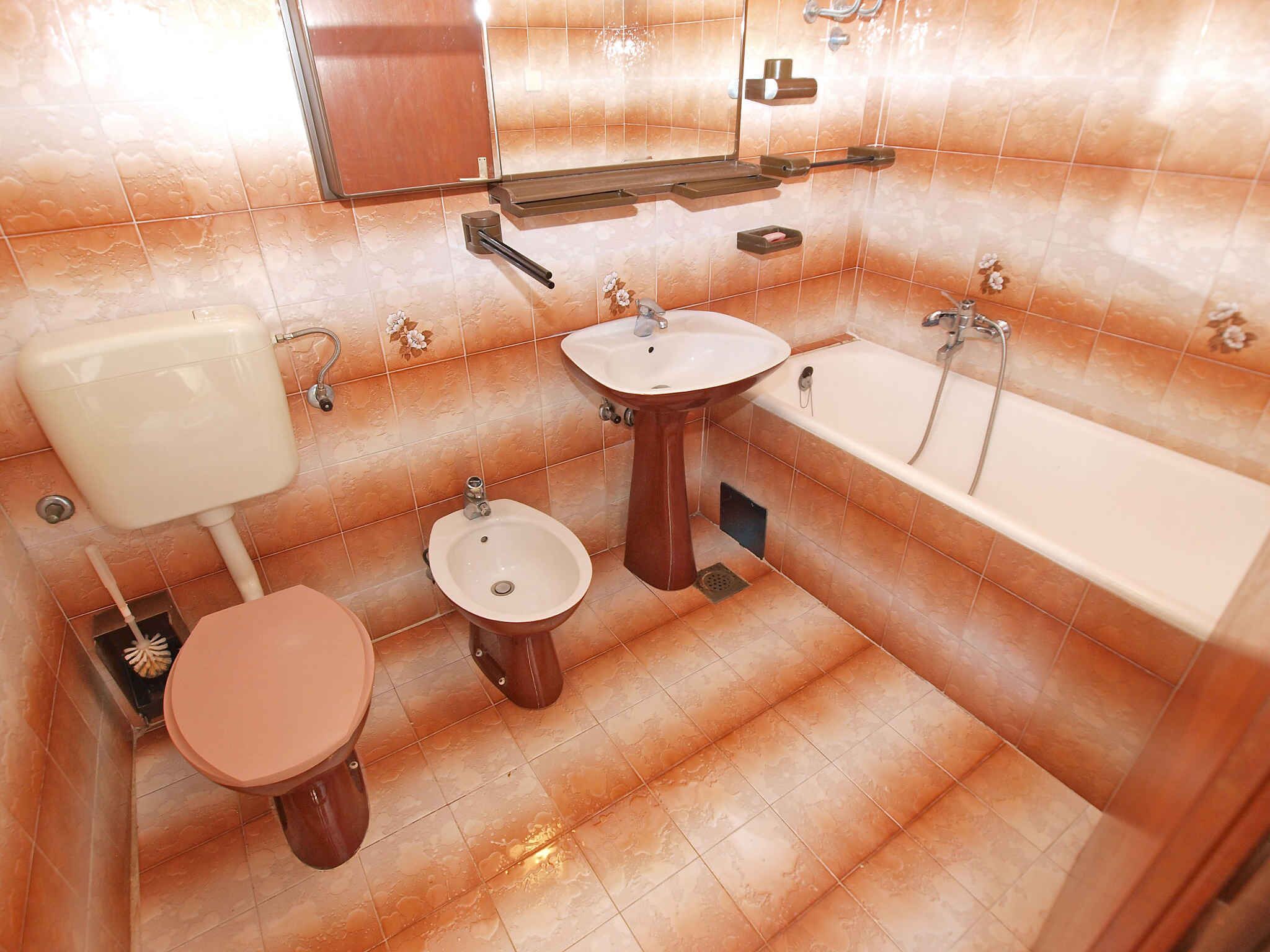 A bathroom with a toilet, bidet, sink, and bathtub.