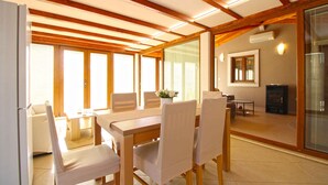 A dining area with a wooden table and chairs, a small side table, and a vase with flowers. There is a fireplace and a mirror on the wall. - Holiday apartment with barbecue (Vinkuran)