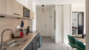 A modern kitchen with a wooden countertop, stainless steel sink, and a toaster.