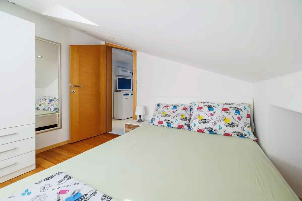 Une chambre à coucher comprenant un lit, une armoire, un bureau et un miroir.