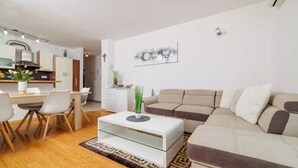 Una sala de estar moderna con sofá, mesa de centro y comedor.