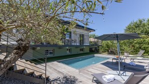 A modern house with a swimming pool, outdoor furniture, and a staircase leading to a balcony. - Villa Violette - Piscine privée (Gujan-Mestras)