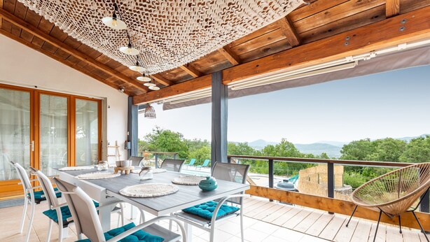 Un comedor con una mesa, sillas y vistas al exterior.