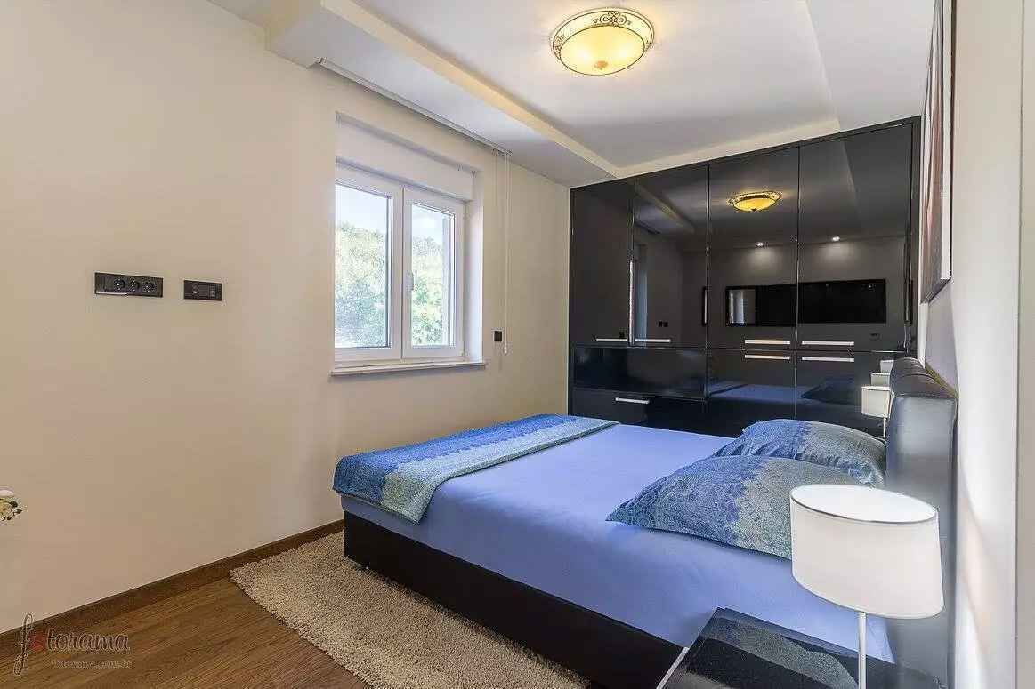 Een moderne slaapkamer met een bed, een grote spiegel en een raam.