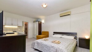 A bedroom with a bed, a chair, a desk, and a TV. - Studio with air conditioning (Fažana)