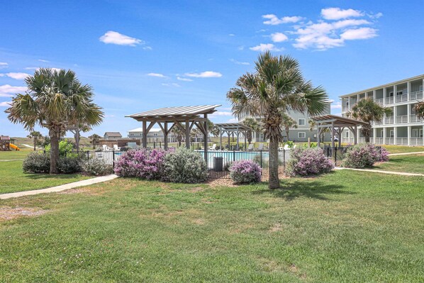 Resort com piscina, áreas de estar cobertas e um edifício com varandas.