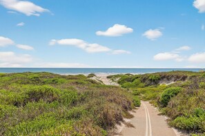 A coastal pathway leading to a beach with dunes and vegetation. - 3BR Beach Condo with Pool View, Private Beach Access (Port Aransas)