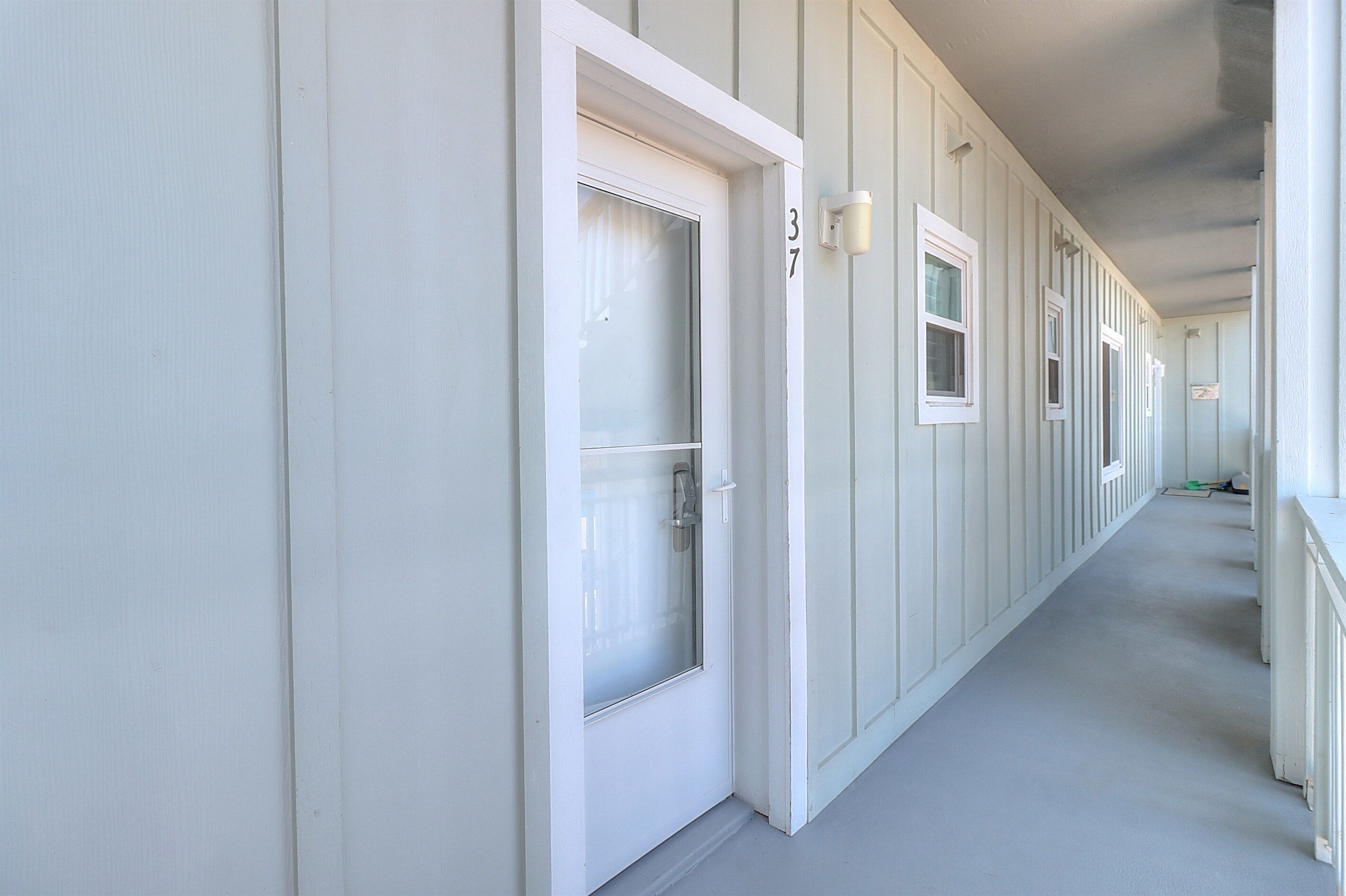 A hallway with white walls and doors, each marked with a number.