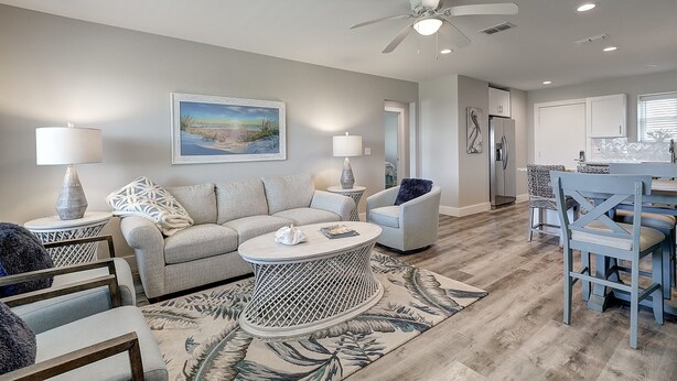 A modern living room with a sofa, coffee table, and chairs, a dining area with a table and chairs, and a kitchen with cabinets and appliances. - Experience Paradise in this Recently Remodeled 3BR/2BA (Port Aransas)