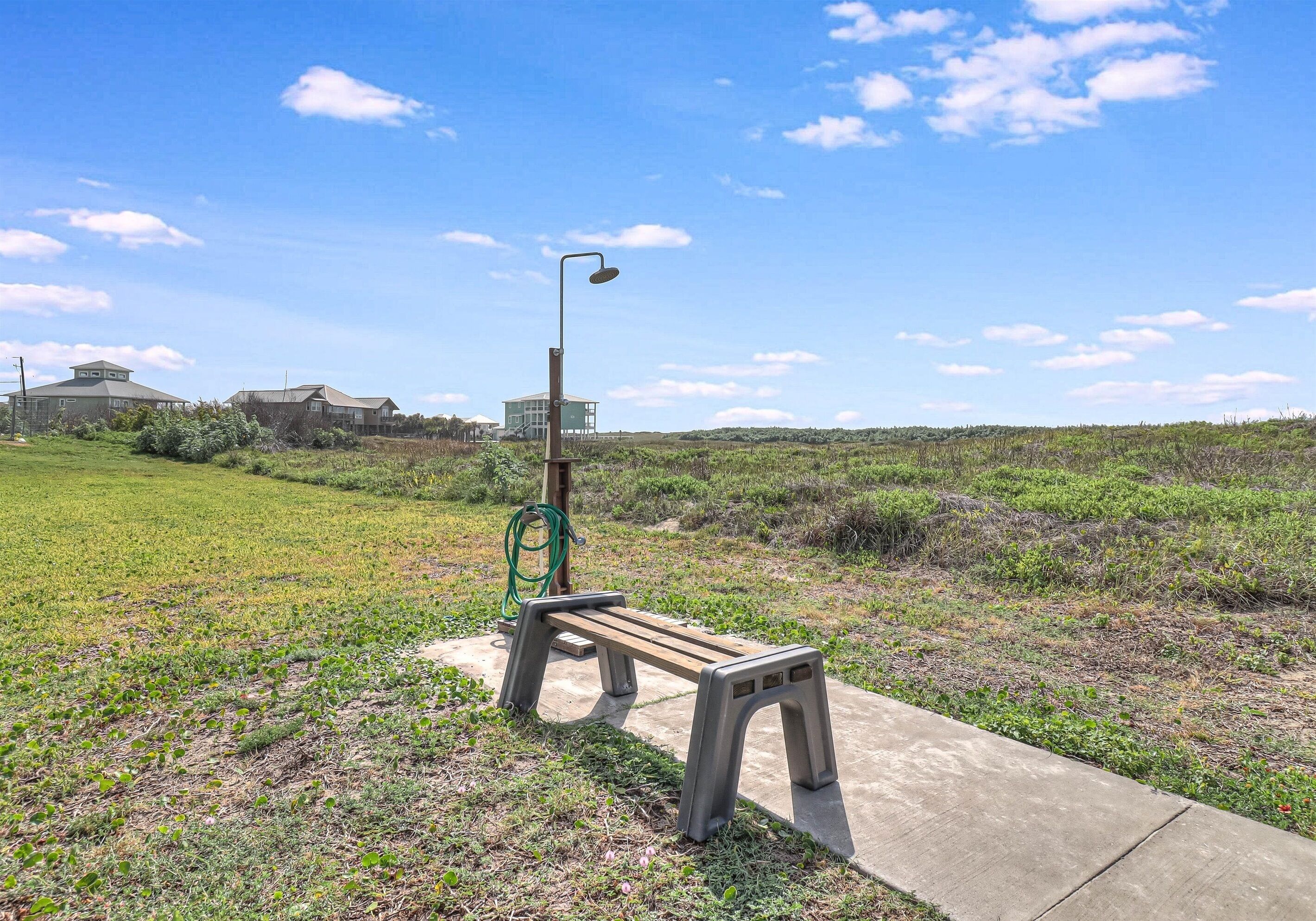 Un banc et un lampadaire dans un espace verdoyant, sous un ciel dégagé.