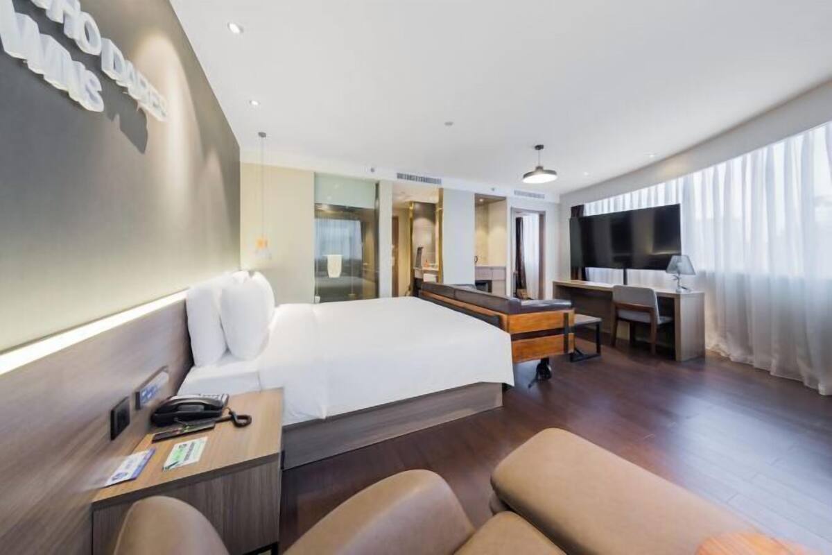 Une chambre d’hôtel équipée d’un lit, d’un bureau, d’une chaise et d’un téléviseur.