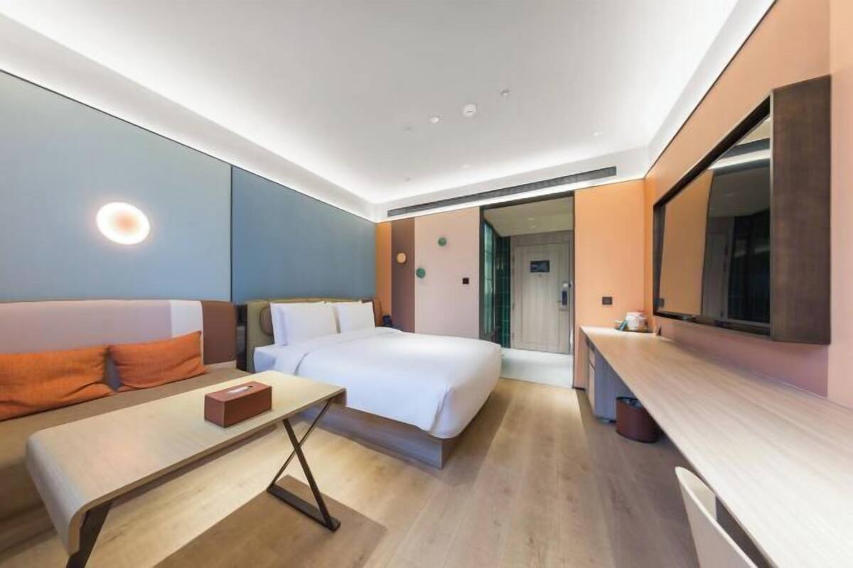 Une chambre d’hôtel moderne équipée d’un lit, d’un bureau et d’un coin salon.