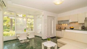 A modern kitchen with white cabinets, a built-in microwave, and a coffee machine. - Holiday apartment with air conditioning (Crikvenica)