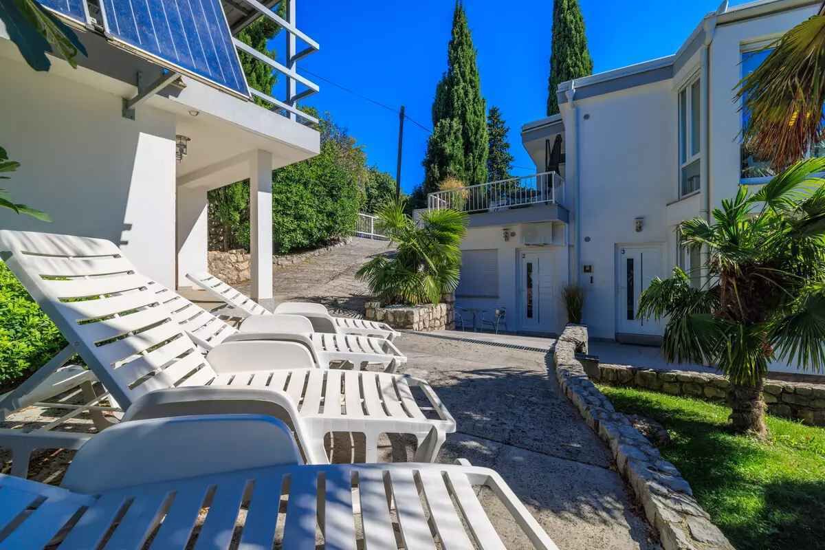 Un complex turístic amb edificis blancs, zones d'estar a l'aire lliure i panells solars.