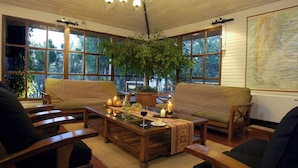 A cozy room with wooden furniture, large windows, and a map on the wall. - Hotel Lar Aike (El Calafate)