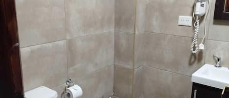 A compact bathroom with a toilet, bidet, and a shower stall.