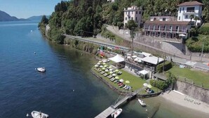 A lakeside hotel with a dock, boats, and a restaurant with outdoor seating. - Holiday apartment with TV and heating (Oggebbio)