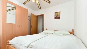 Ein Schlafzimmer mit einem Bett, einem Holzschrank und einer Tür zu einem anderen Raum.