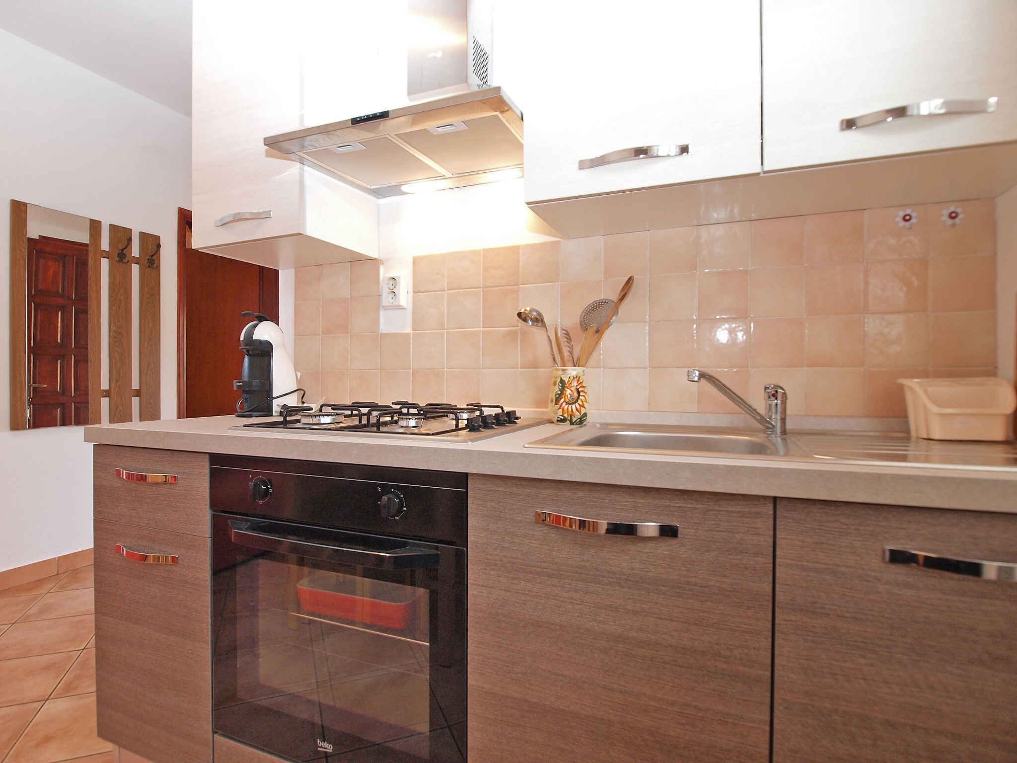A modern kitchen with a gas stove, oven, and stainless steel sink.