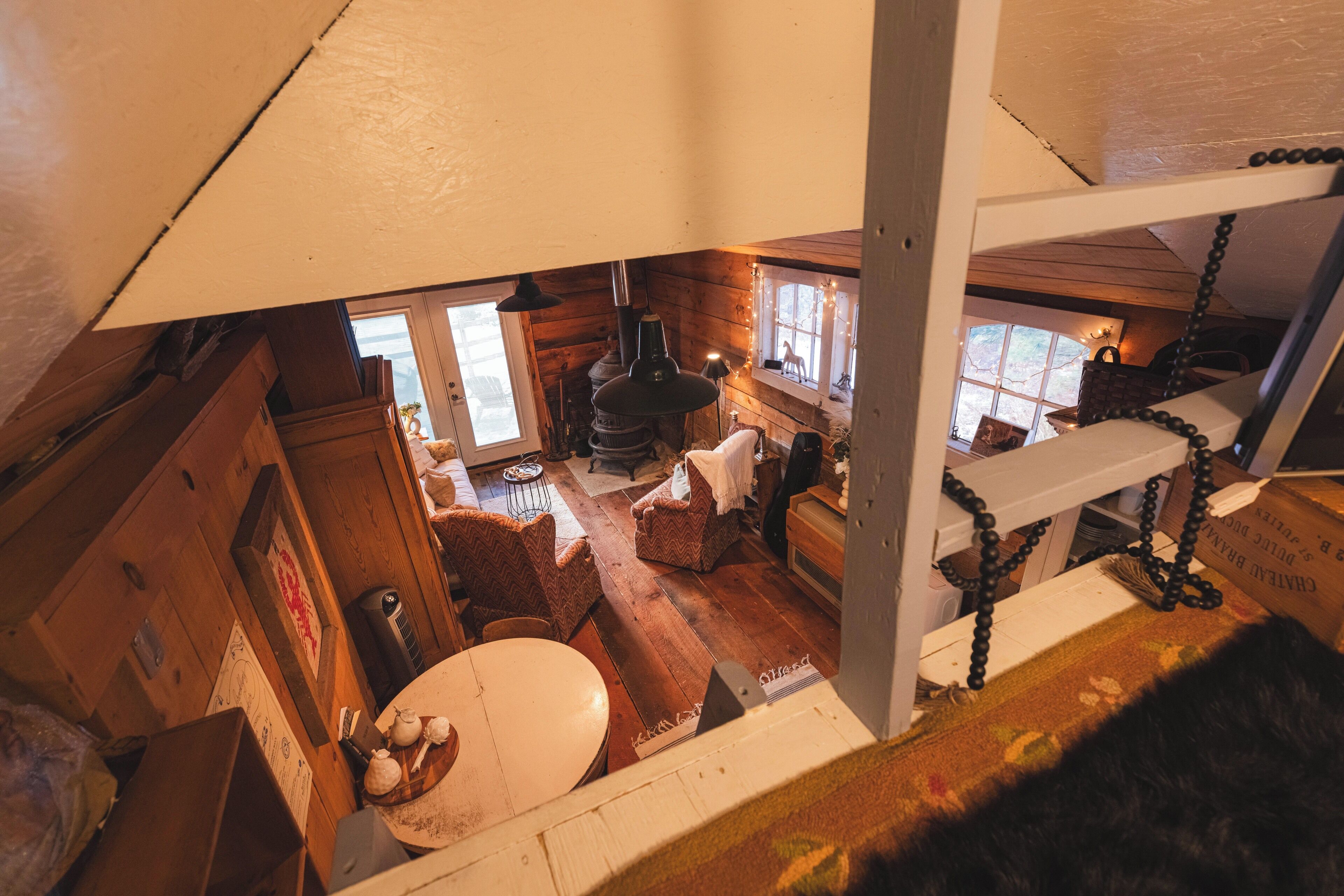 Un interior de cabaña acogedor con piso de madera, chimenea y comedor.