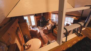 Un interior de cabaña acogedor con piso de madera, chimenea y comedor.