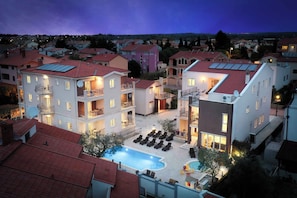 Ein mehrstöckiges Hotel mit Pool, Balkonen und Innenhof.