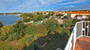 A coastal town with a marina, residential buildings, and lush greenery. - Holiday apartment with sea view (Pješćana Uvala)