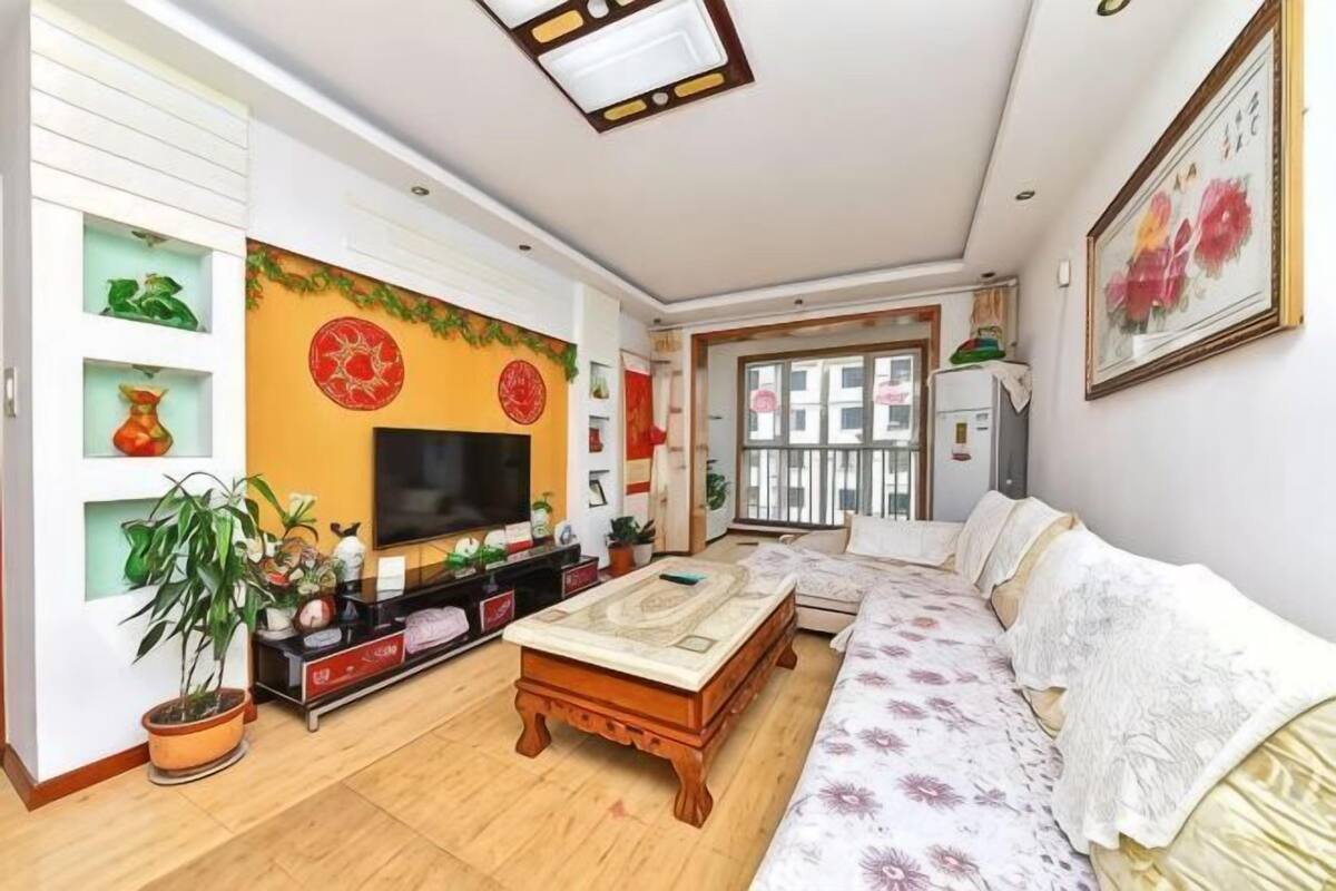 A living room with a sofa, TV, and decorative items.