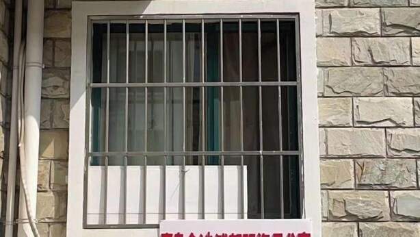 A window with metal bars, a stone wall, and a white pipe. - Qingdao Golden Beach Chaoyang Seaview Apartment (Qingdao)