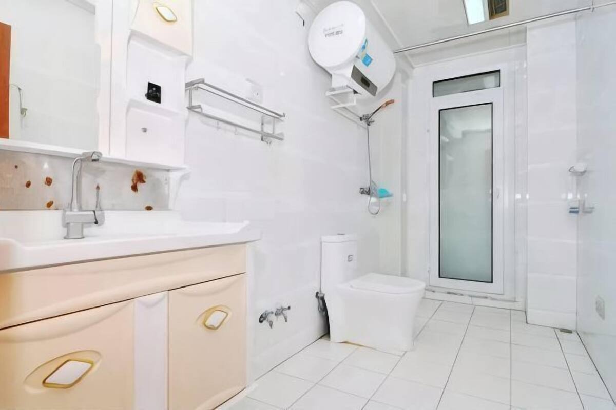 A modern bathroom with a white sink, toilet, and shower.
