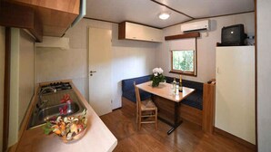 Una cocina compacta con lavamanos, estufa y comedor con mesa y sillas.