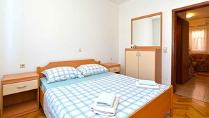 Una camera da letto con un letto singolo, un comodino, un armadio e uno specchio.