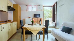 Un espace de vie compact comprenant un coin cuisine, un coin repas et un canapé.