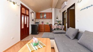 A compact living space with a kitchenette, a sofa, and a dining table. - Holiday apartment with garden and air conditioning (Medulin)