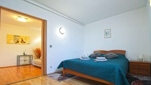 A bedroom with a bed, bedside table, and a nightstand. - Holiday apartment with air conditioning (Pješćana Uvala)