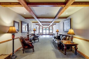 A hallway with a reception desk, seating area, and framed artwork on the walls.