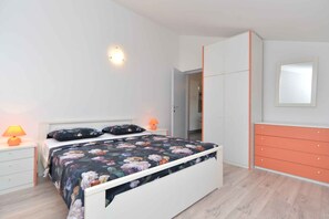 Ein Schlafzimmer mit Bett, Nachttischen, einem Schminktisch und einem Kleiderschrank.