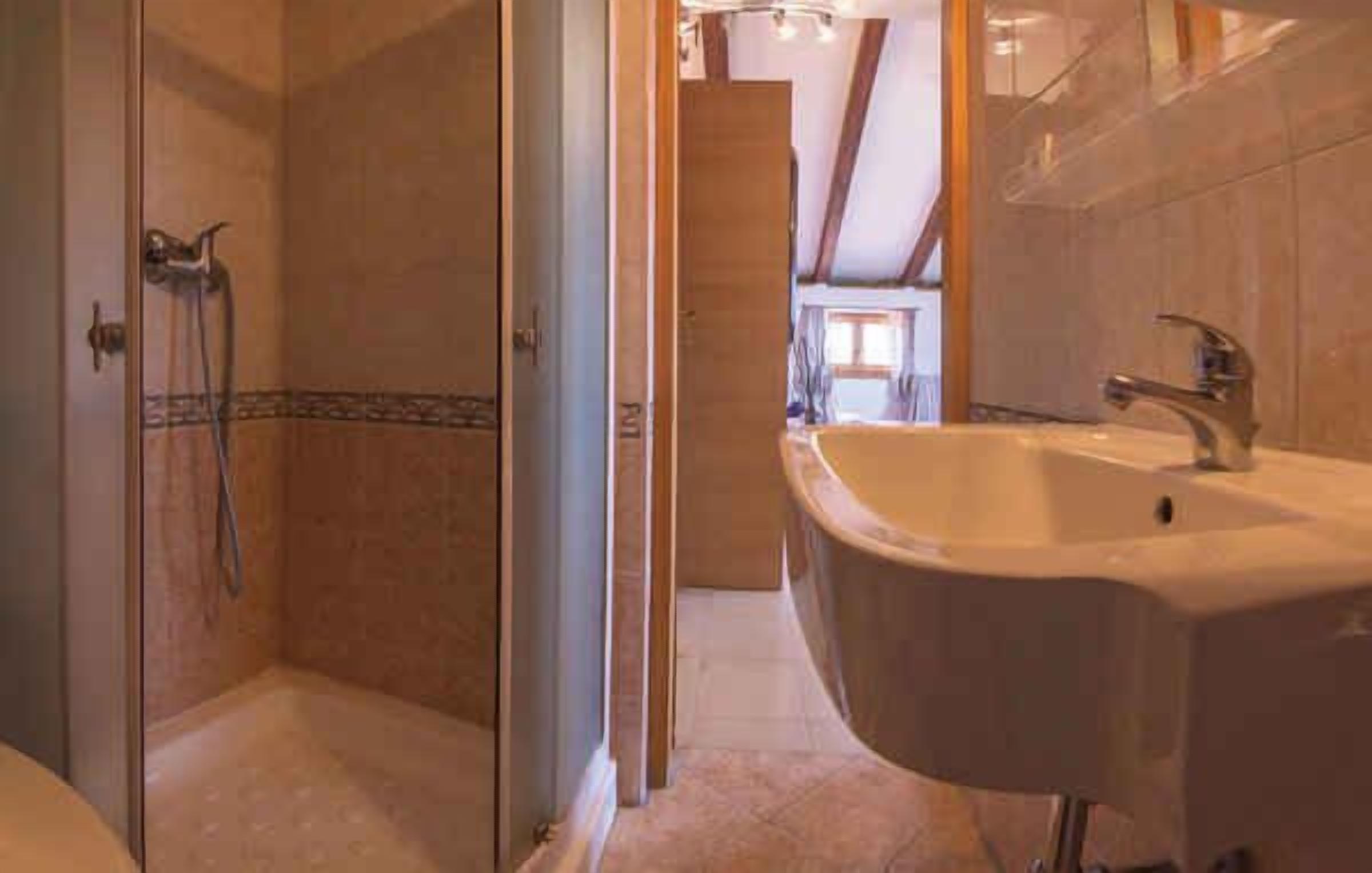 A bathroom with a shower, a sink, and a mirror.