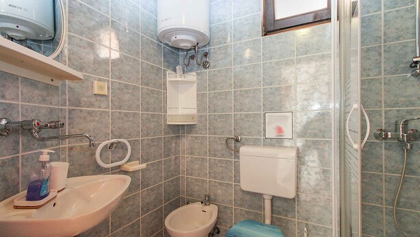 Ein Badezimmer mit Waschbecken, Toilette, Bidet und Dusche.