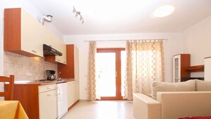 A compact living space with a kitchenette, a sofa, and a dining area.