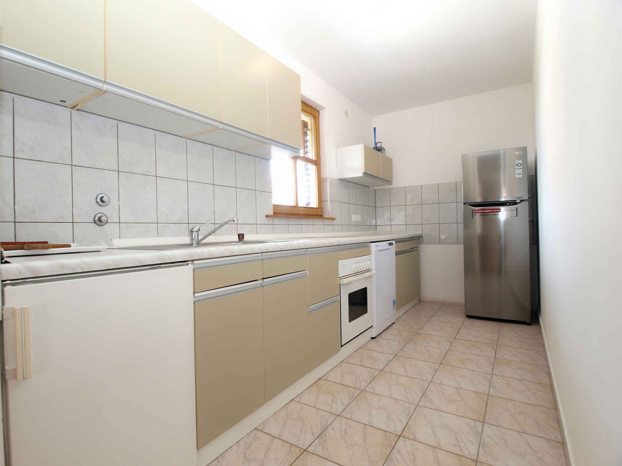 A kitchen with a stainless steel refrigerator, a built-in oven, and a dishwasher.
