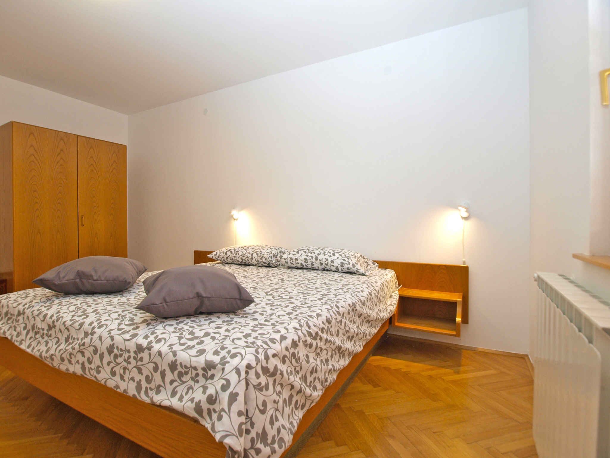 Une chambre à coucher comprenant un lit, deux tables de chevet, une armoire et un radiateur.