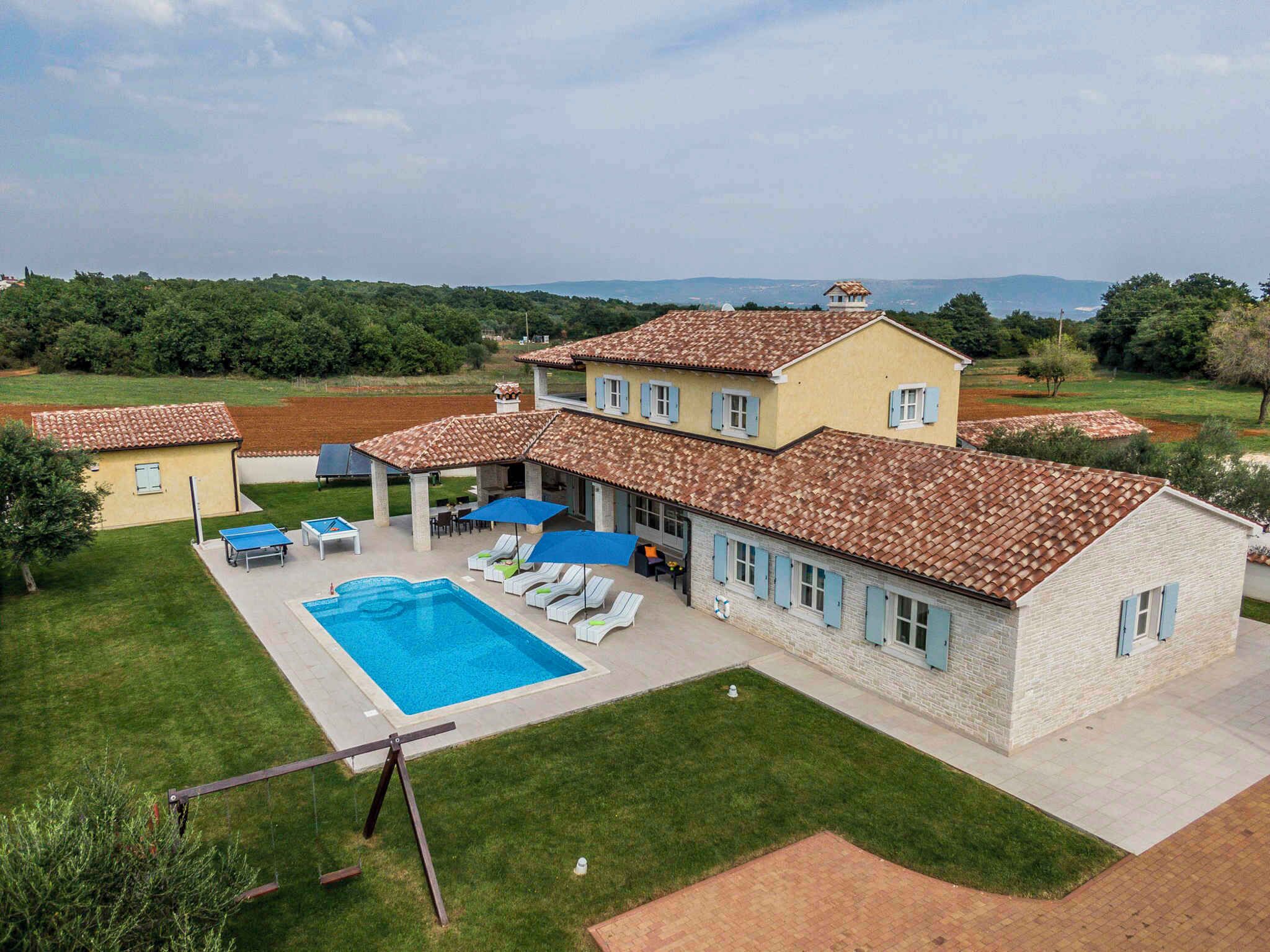 Una casa de dos pisos con piscina, mobiliario exterior y vistas al campo.