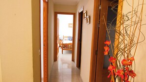 A hallway with wooden doors, a tiled floor, and a ceiling with a decorative cornice. - Centro Cerca Playa (Benidorm)
