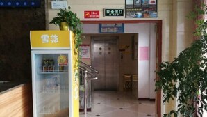 A hallway with a vending machine, a staircase, and a door leading to an elevator. - Junyi Chain Hotel (Haiyan Qiyuan Chengbei East Road) (Haiyan)