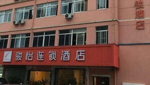 A hotel with a red facade and multiple windows. - Junyi Chain Hotel (Haiyan Qiyuan Chengbei East Road) (Haiyan)