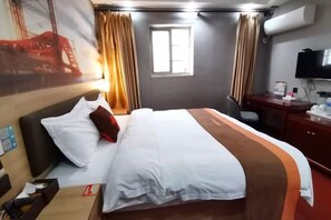 A hotel room with a bed, a desk, a chair, a television, and a window. - Junyi Chain Hotel (Haiyan Qiyuan Chengbei East Road) (Haiyan)