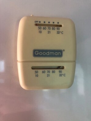 A thermostat with temperature settings and a brand name 'Goodman'.
